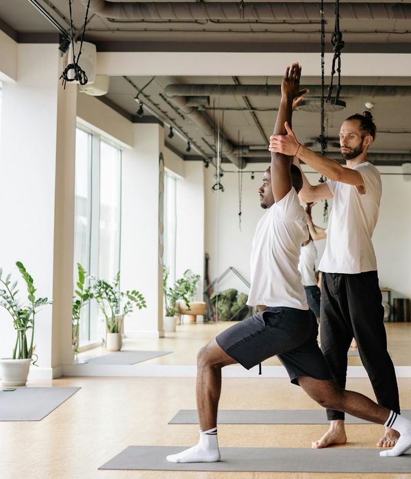 Friendly yoga instructor welcoming a new student to the class.