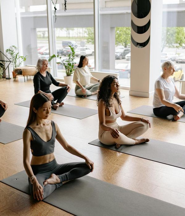 Group of diverse people practicing yoga in a bright, modern studio.